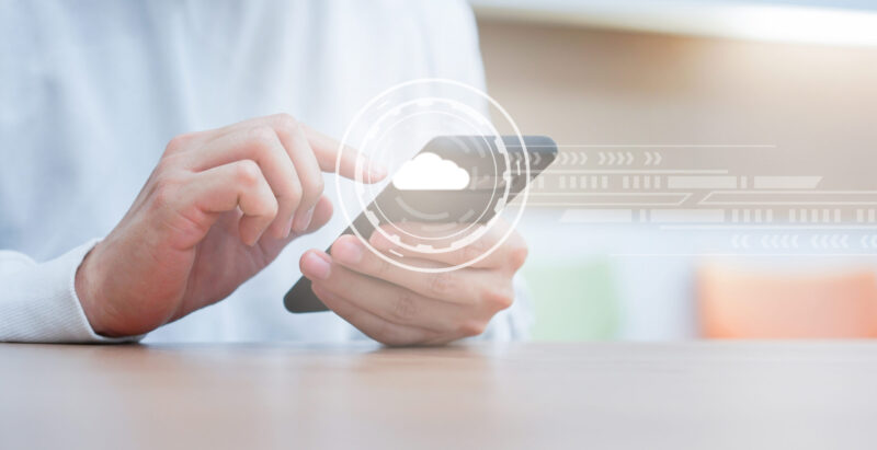 close up man hand touch screen on smart phone to transfer or synch data upload and download from cloud computing storage technology service with virtual interface at home for lifestyle and business concept